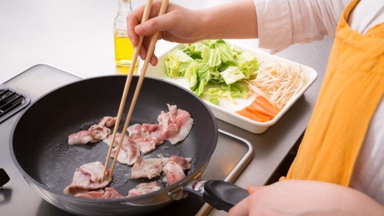 フライパンで肉を炒める