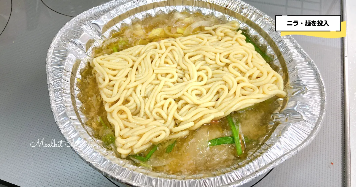 ニラと麺をもつ鍋に投入