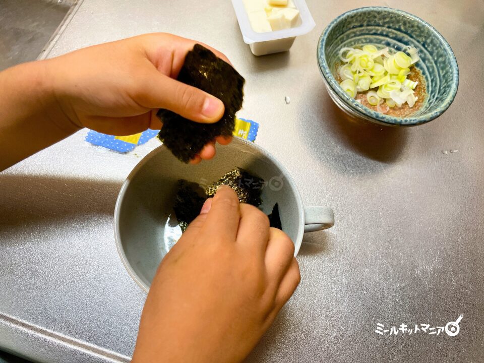 オイシックス：ミールキット（ジューシーそぼろと野菜のビビンバ）海苔をちぎる子ども